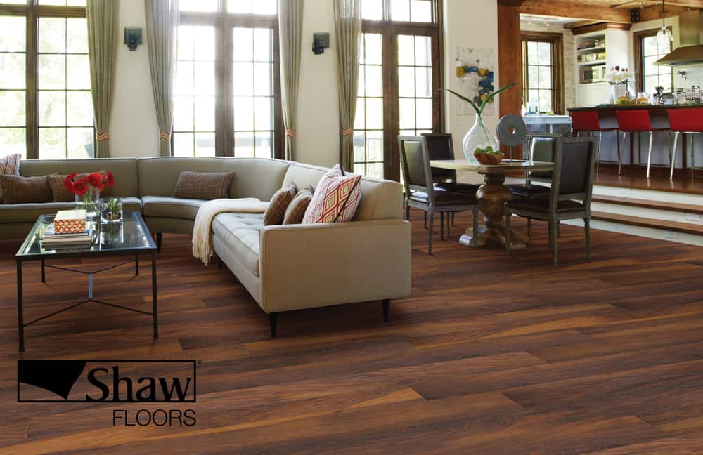SHAW Natural hardwood flooring in modern living room with large windows and cozy seating.