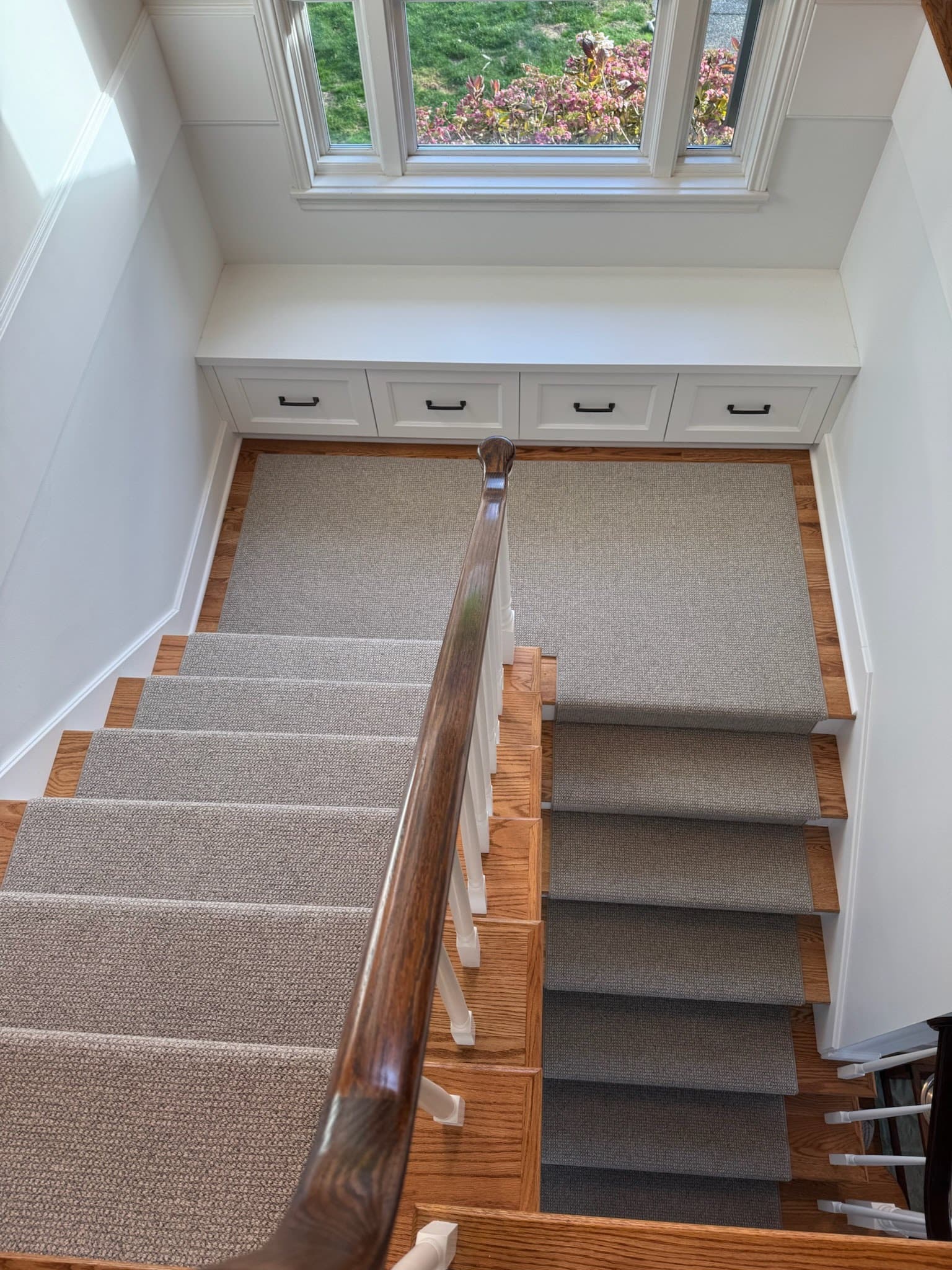 Luxurious staircase with beige carpet runners and wooden stairs, perfect for modern home flooring.