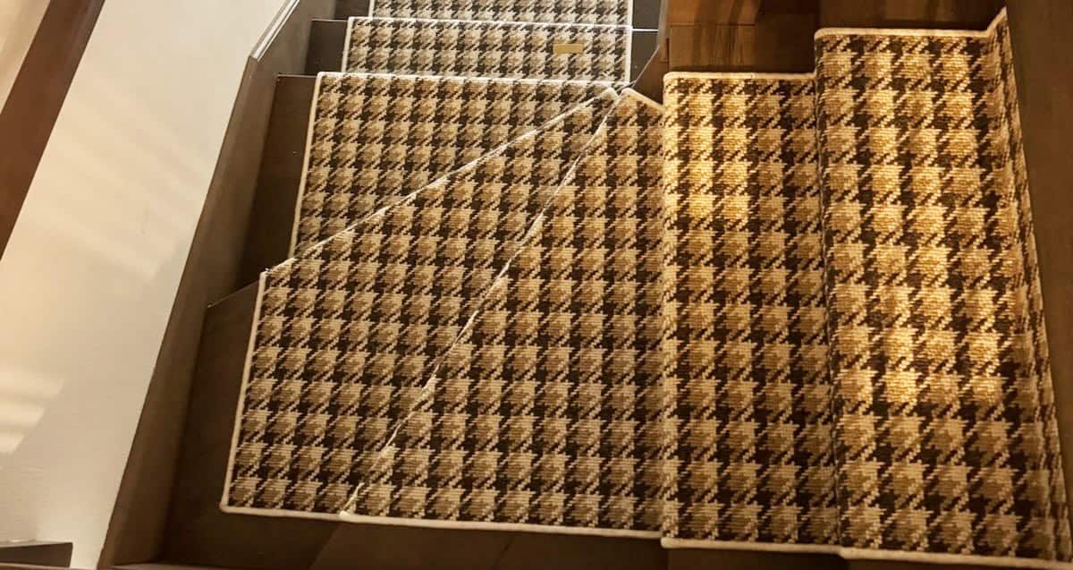 Patterned carpet flooring with houndstooth design on stair treads and risers.