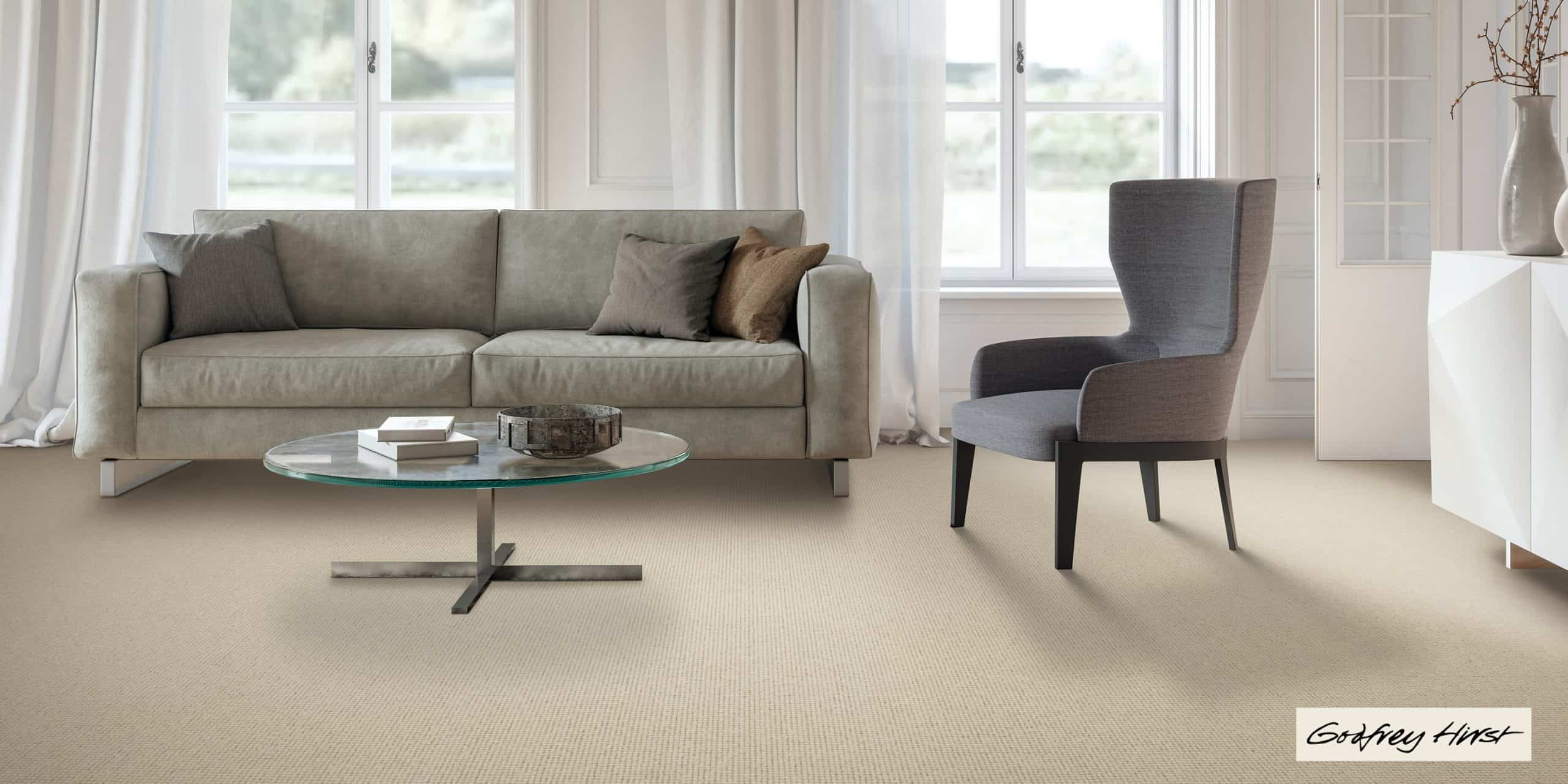 godfreyhirst Smooth beige carpet flooring in a cozy living room with modern furniture and large windows.