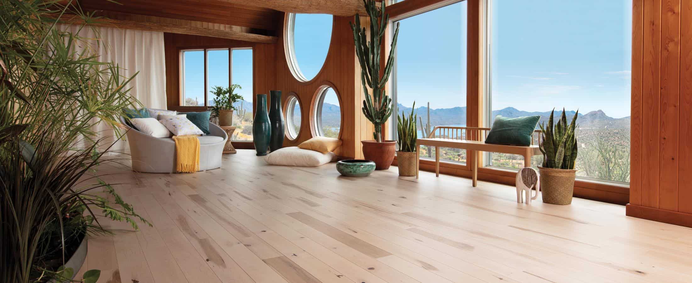 Bright natural wood flooring in stylish living room with large windows and indoor plants, perfect for modern home decor.